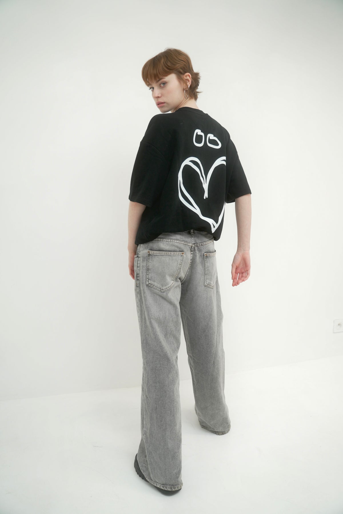 Photo portée du t-shirt Noir Joly avec un mannequin féminin, logo coeur en blanc au dos.