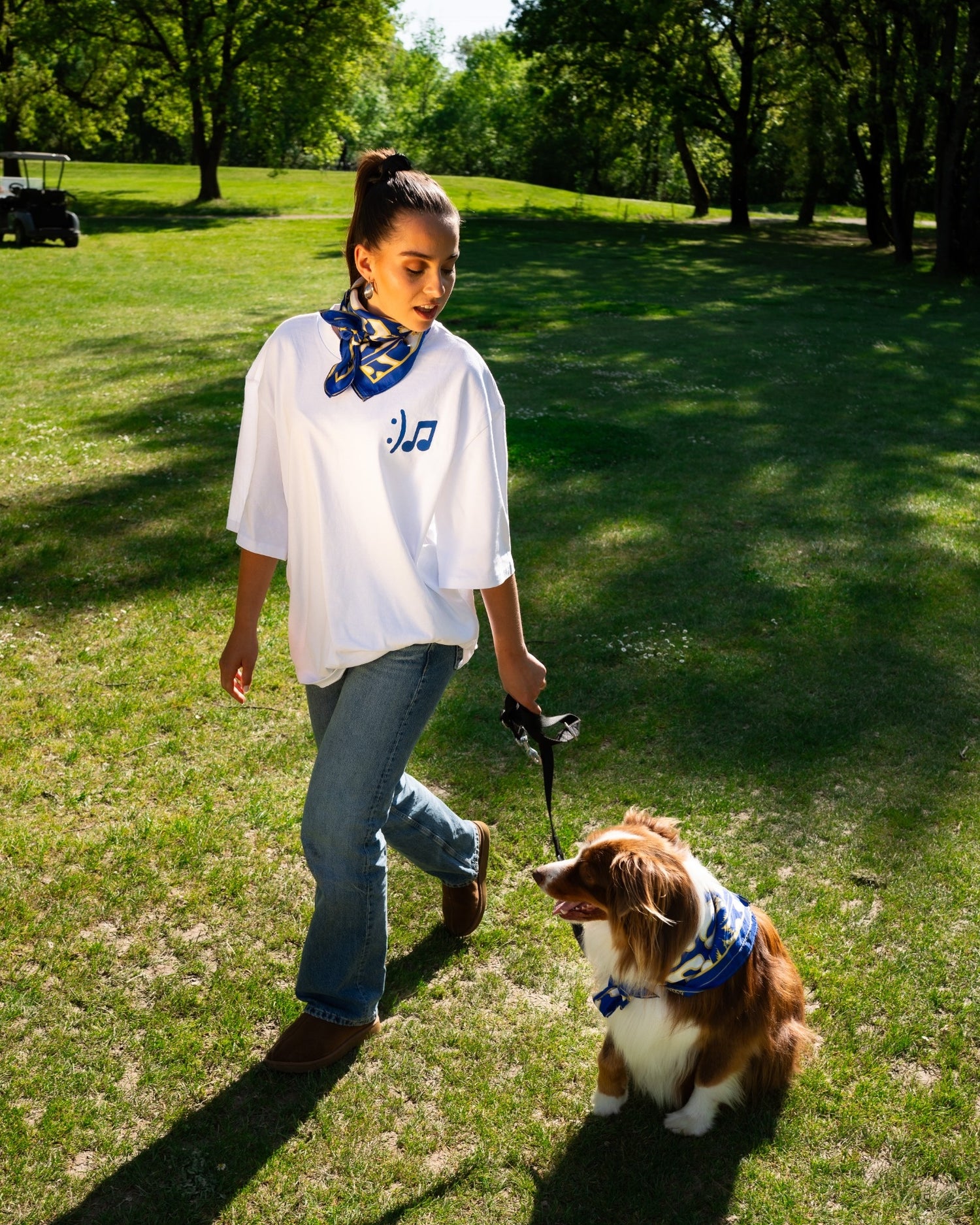 Camille Marchandeau en train de marcher avec le t-shirt et le foulard en soie gentes et son chien.
