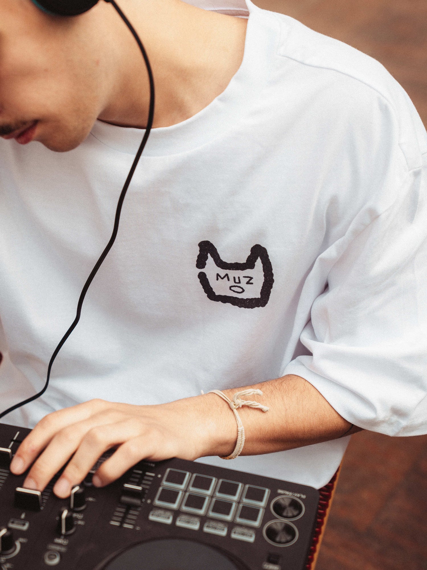 Felix en train de mixer de la musique house, avec un zoom devant sur le logo Muzo au coeur